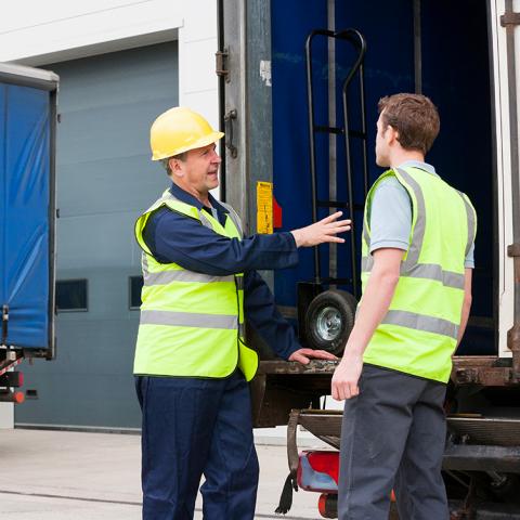 Man met helm geeft laadtips voor vrachtwagen