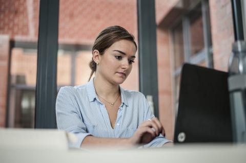 Jonge vrouw tikt op computer
