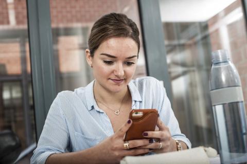 Jonge vrouw tikt op gsm
