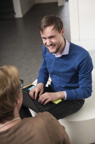 Jongeman op laptop in gesprek