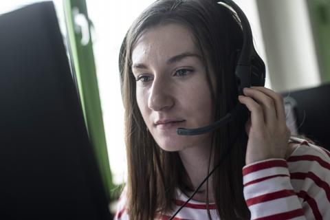 Jonge vrouw met headset en laptop
